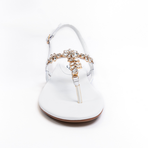 
                  
                    Load image into Gallery viewer, A front shot of a beautiful white women&amp;#39;s thong style sandal with a flat heel, sling back with buckle, and clear gemstones held with gold casing.
                  
                